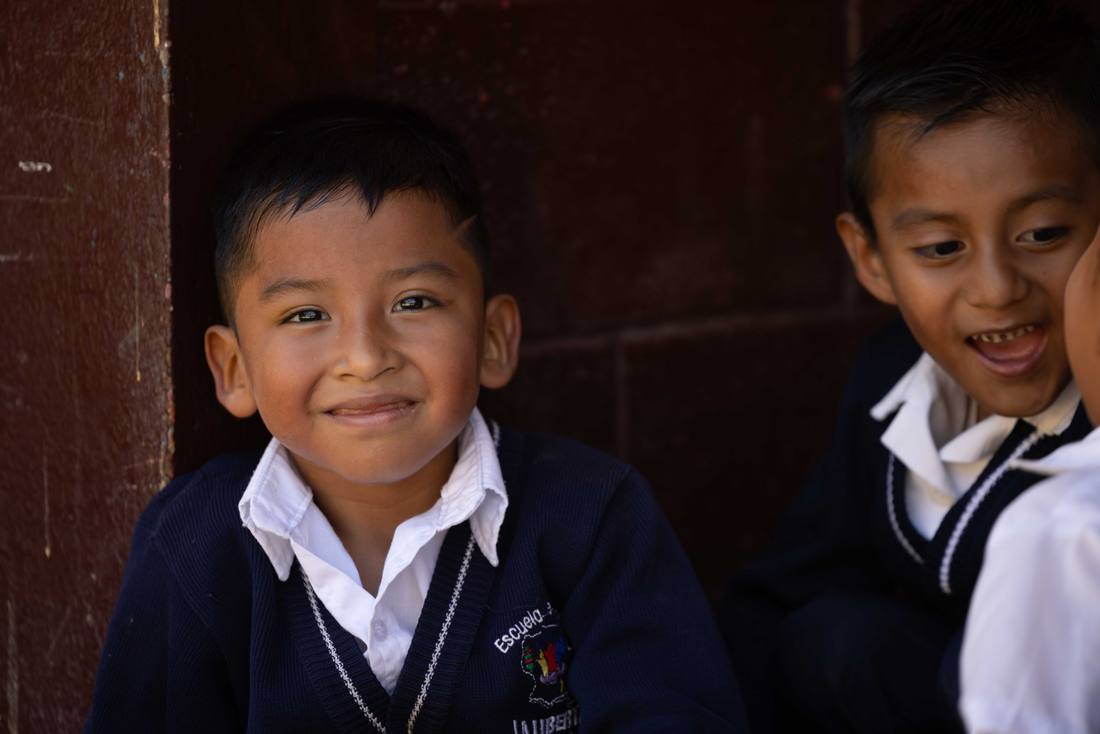 Two students smiling outside their classroom